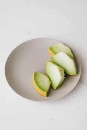 slices of melon in plate placed on table